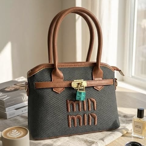 Elegant Black Textured Structured Handbag for Women with Tan Brown Top Handles, Gold-Tone Lock Detail and Classic Dual-Colour Design